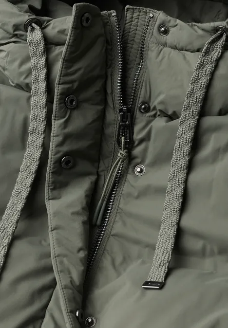 Nahaufnahme einer olivgrünen Steppjacke mit Reißverschluss und geflochtenen Zugbändern