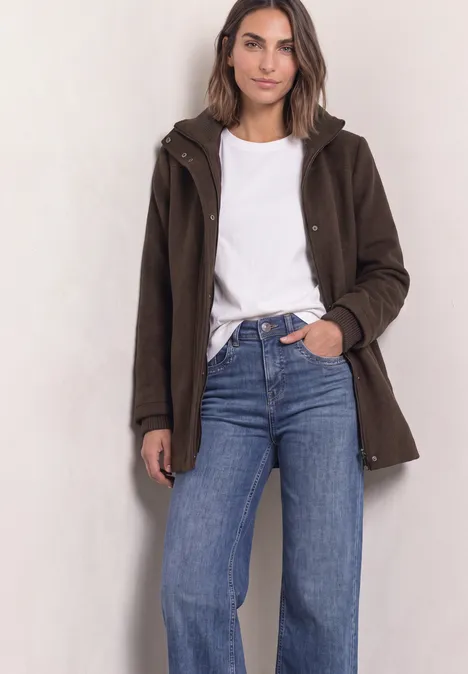 Kurzer Mantel mit Strickdetails auburn brown Frau in weißem Shirt, blauer Jeans und braunem Mantel vor hellem Hintergrund