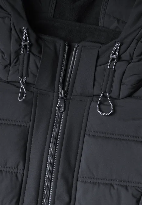 Nahaufnahme einer schwarzen Steppjacke mit Reißverschluss und Kordelzügen.