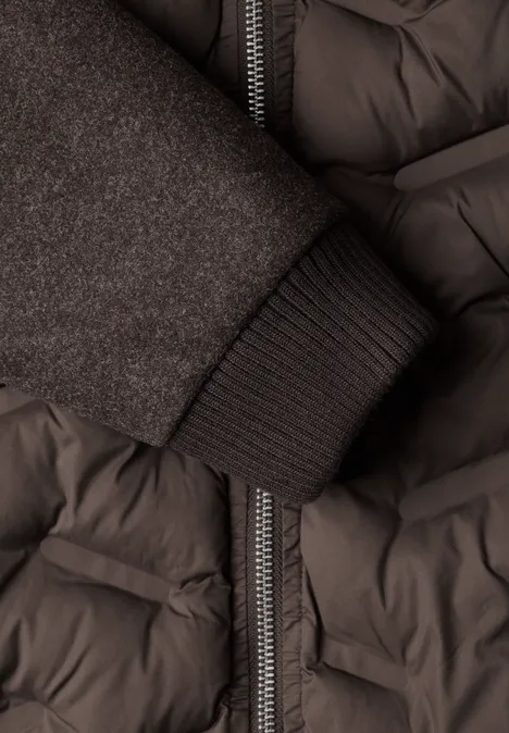 Strukturmix Jacke mit geklebter Steppung auburn brown Nahaufnahme eines dunkelgrauen Steppmantels mit Reißverschluss und einem Strickbündchen