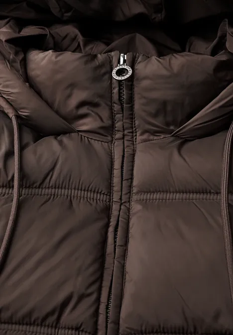 Nahaufnahme einer braunen Steppjacke mit Reißverschluss und Kapuze.