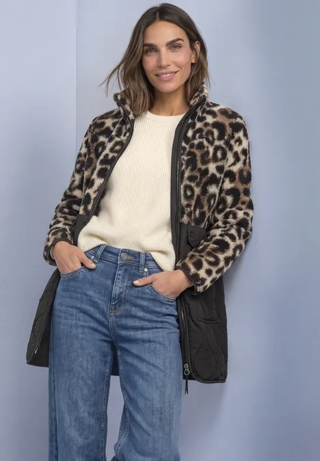 Strukturmix Teddy-Mantel mit Steppdetails Black Eine Frau mit Leopardenjacke, weißem Pullover und Jeans steht lächelnd vor hellem Hintergrund.
