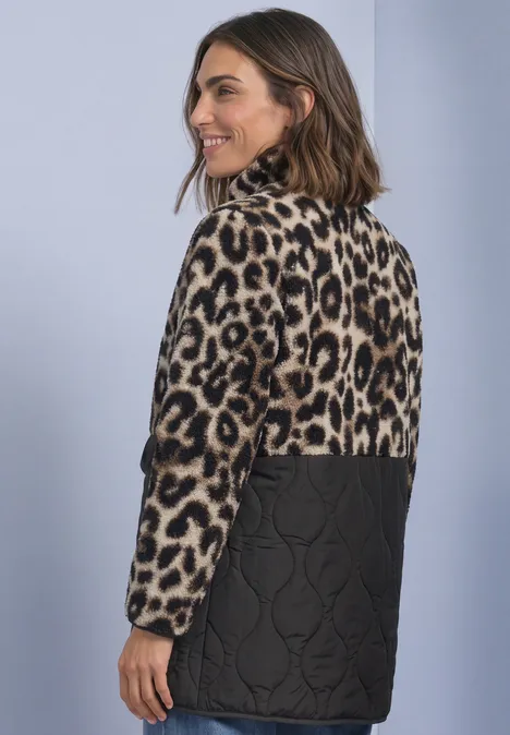 Strukturmix Teddy-Mantel mit Steppdetails Black Frau im Rückenblick mit modischer Jacke: Leopardmuster oben, gesteppte schwarze Unterseite.