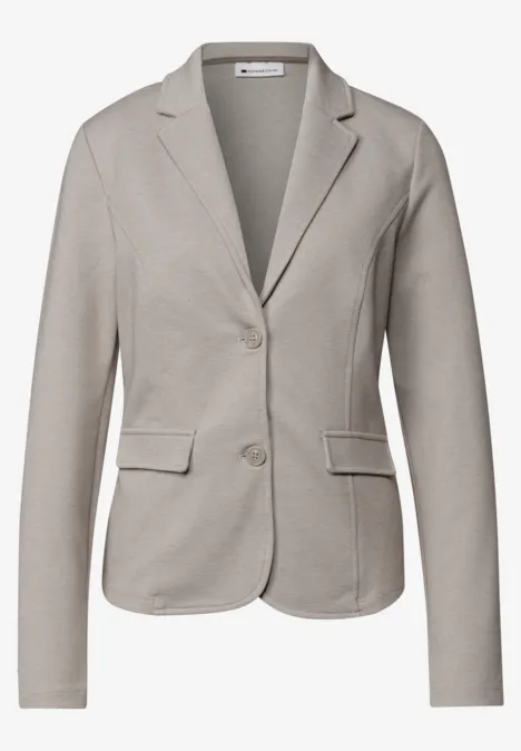 Een getailleerd damesblazer in grijs-beige met reverskraag, twee knopen en klepzakken.