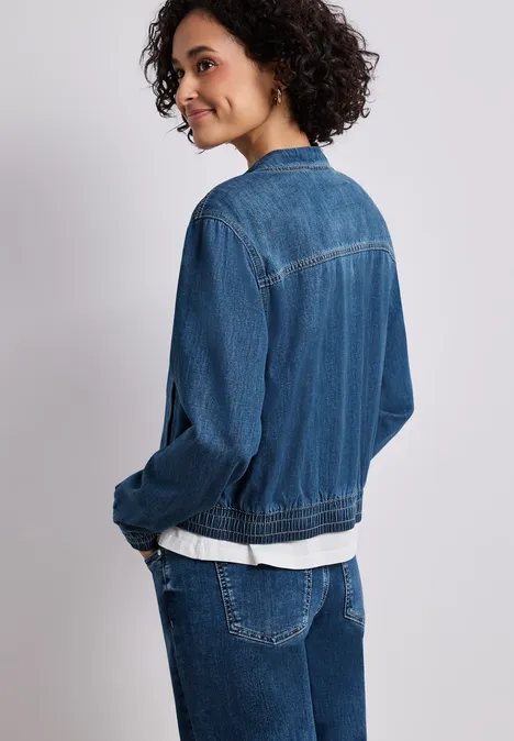 Denim-look blouson met ritssluiting Medium Blue washed Zijaanzicht van een persoon in spijkerjack, spijkerbroek en wit T-shirt tegen een neutrale achtergrond.