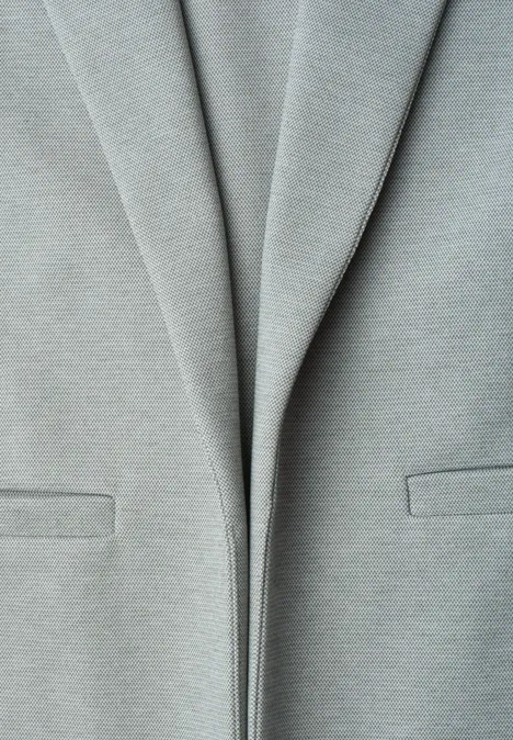 Blazer im langen und offenen Schnitt bound green Nahaufnahme eines hellgrauen Blazers mit leichten Falten und dezenten Taschen.