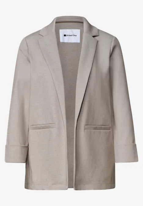 Blazer beige décontracté à coupe ouverte et poches plaquées.