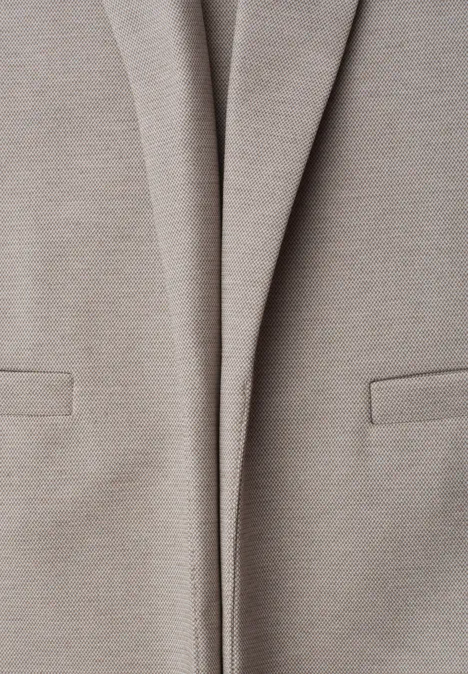 Gros plan sur une veste blazer beige clair avec poches sur le devant