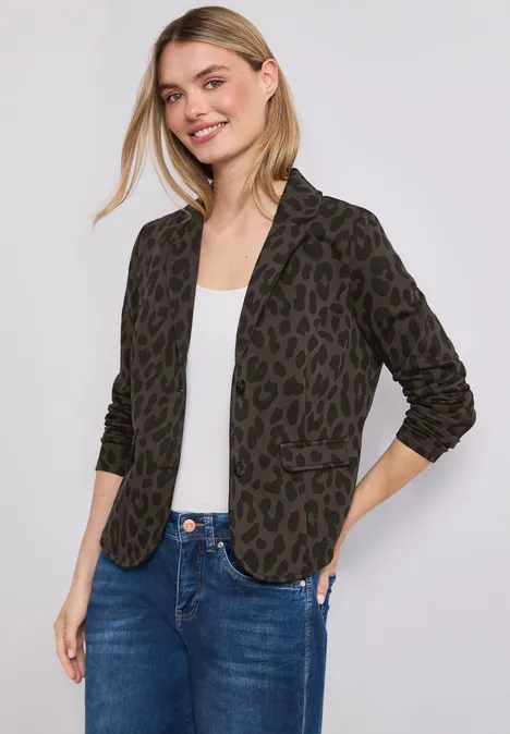 Frau mit Leopardenmuster-Blazer, weißem Shirt und Jeans.