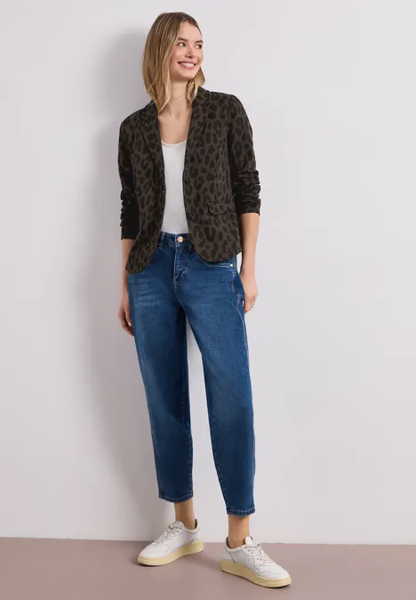 Person trägt Leoprint-Blazer, weißes Top, lockere blaue High-Waist-Jeans und weiße Sneaker.