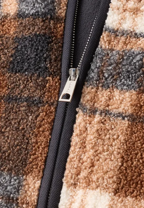 Teddy-Jacke mit Rundhals und Print Obsidian Blue Nahaufnahme eines karierten Teddy-Fleecestoffs in Beige- und Brauntönen mit schwarzem Reißverschluss.