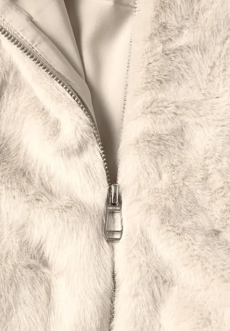 Kurze Fake-Fur-Mix Jacke mit Kapuze smooth stone sand Nahaufnahme eines hellen, flauschigen Kleidungsstücks mit geöffnetem Reißverschluss.