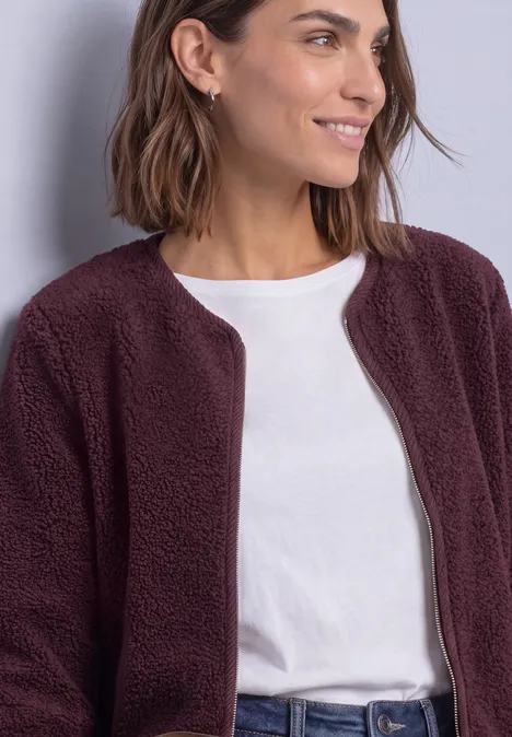 Teddy-Jacke mit Rundhals und Corddetails rustic rouge Frau in weißem T-Shirt und bordeauxfarbenem Teddy-Fleece-Jacke, lächelnd seitlich schauend