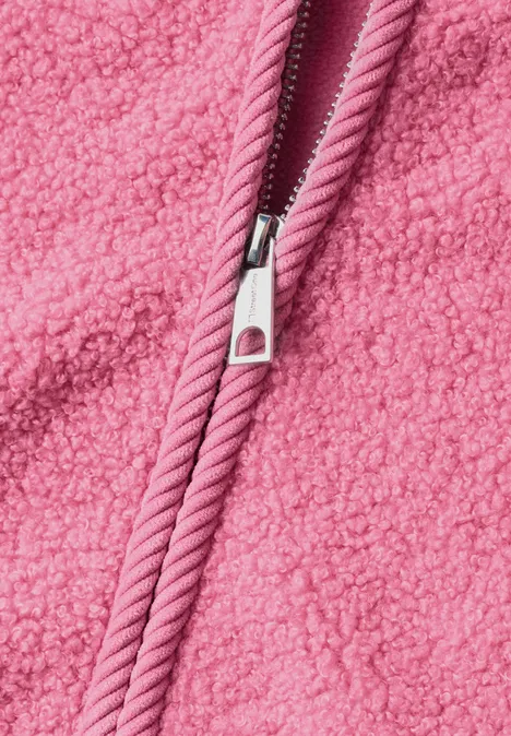 Nahaufnahme eines rosa Reißverschlusses auf flauschigem Teddy-Fleece-Stoff.