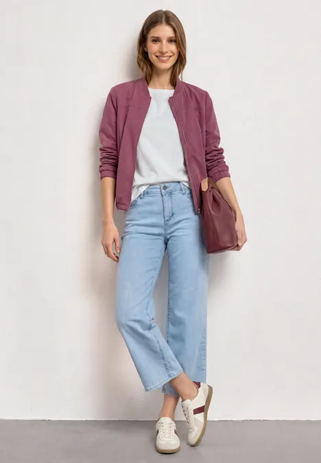 Blouson met lange mouwen en ritssluiting dark clouded blush Persoon draagt paarse bomberjack, wit T-shirt, lichte jeans en witte sneakers, met een bruine tas.