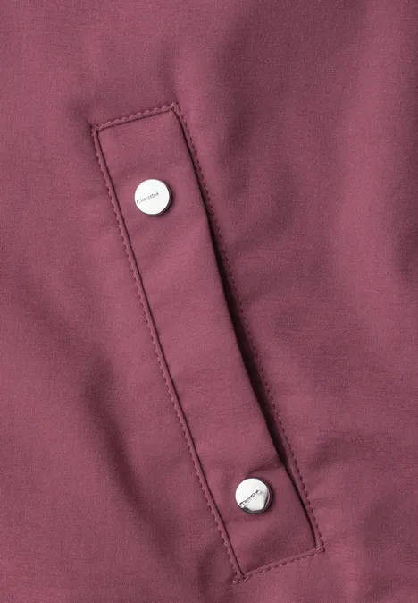 Blouson met lange mouwen en ritssluiting dark clouded blush Close-up van een bordeauxrode stof met een lusje en twee zilverkleurige drukkers.
