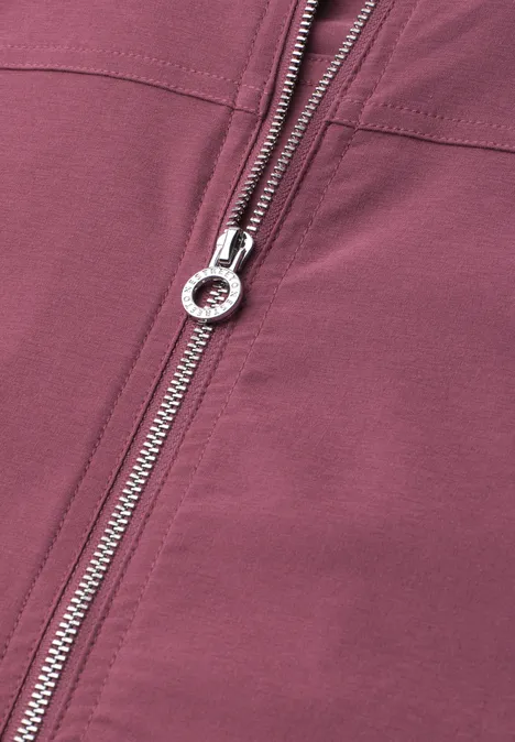 Blouson met lange mouwen en ritssluiting dark clouded blush Close-up van een zilveren ritssluiting op bordeaux stof.