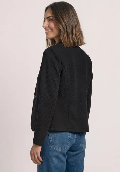 Blazer mit Reverskragen und Struktur Black Frau in seitlicher Pose trägt schwarzen Blazer mit 3/4-Ärmeln und blaue Jeans, lächelnd zur Seite blickend.