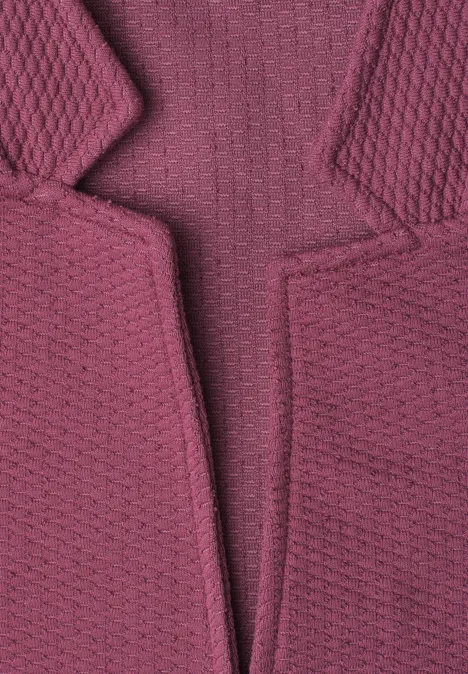 Close-up van een gestructureerd, gebreid, paars kledingstuk met revers.