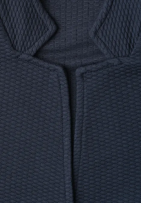 Gros plan sur un tissu rembourré sombre à motif alvéolaire.