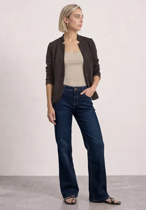 Blazer mit Reverskragen und Struktur black coffee mel. Eine Frau im dunklen Cardigan, beigem Top, weiten dunkelblauen Jeans und Sandalen vor neutralem Hintergrund.