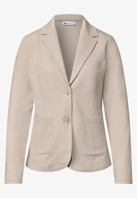 Beiger Damenblazer mit Reverskragen, zwei Knöpfen und aufgesetzten Taschen.