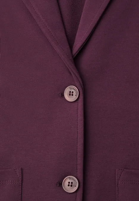 Nahaufnahme eines dunkelvioletten Blazers mit Knöpfen und Taschen.