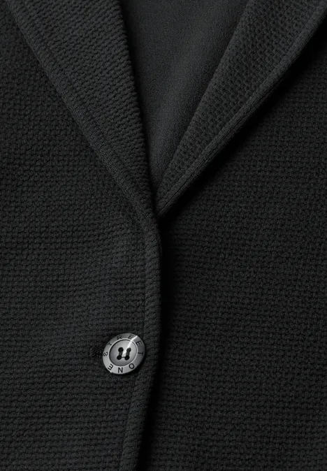 Schwarzer, fein strukturierter Blazer mit Reverskragen und einzelner Knopfleiste aus nächster Nähe.