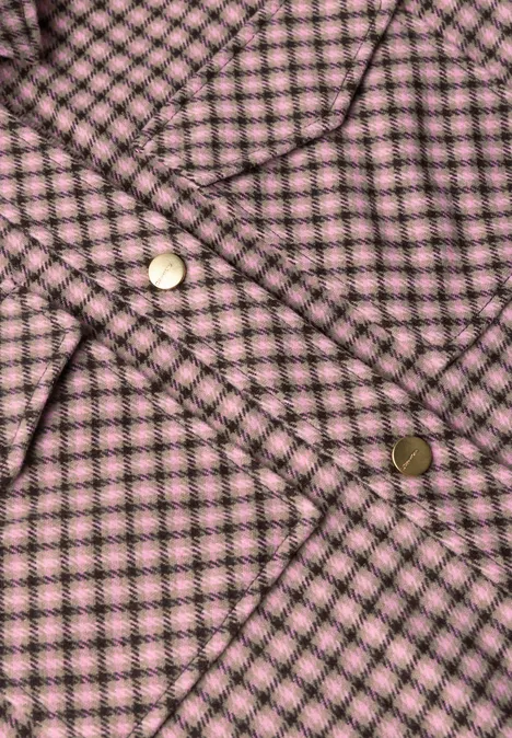 Overshirt z kieszeniami na piersi i wzorem w kratkę warm blush Zbliżenie różowej kraciastej tkaniny z złotymi zatrzaskami.