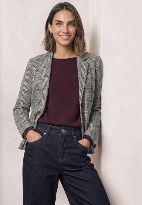 Blazer à carreaux et boutons Black Eine Frau in grauem Blazer, bordeauxrotem Pullover und dunkler Hose.