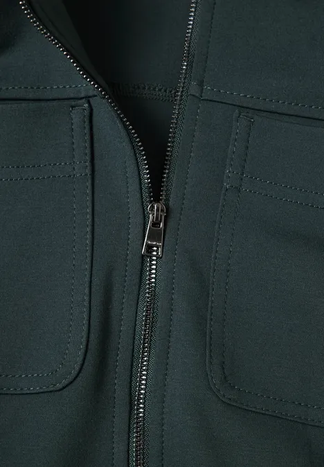 Close-up van een donker kledingstuk met centrale ritssluiting en twee opgezette zakken.