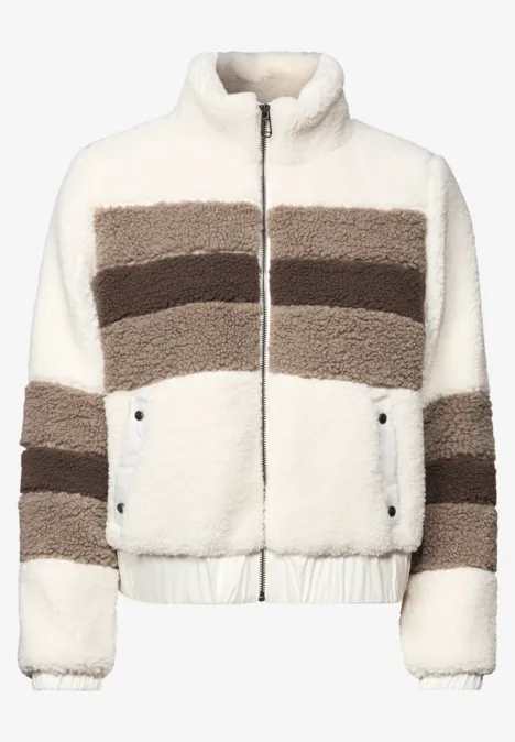 Kurze Teddyjacke in Weiß mit braunen Streifen, Reißverschluss und seitlichen Taschen.