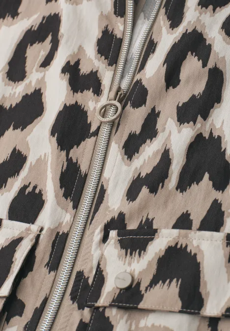 Detailaufnahme eines Reißverschlusses auf beige-braunem Leopardenmusterstoff mit aufgesetzter Tasche.