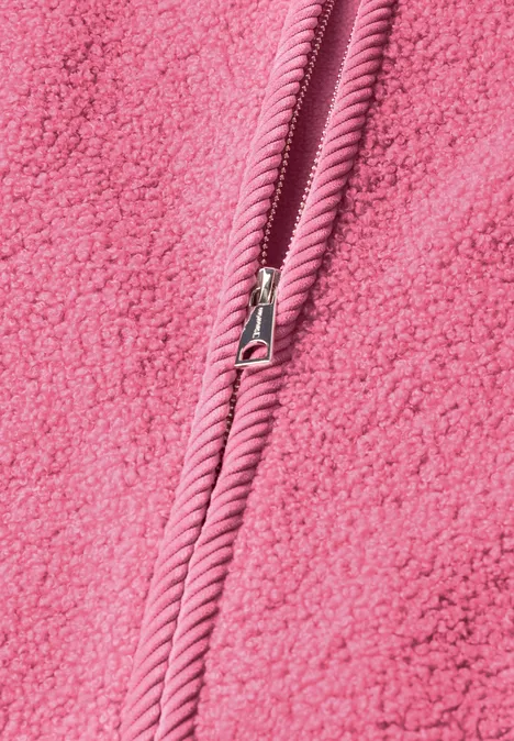 Close-up van roze fleece met een centrale rits.