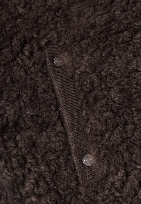 Nahaufnahme einer dunkelbraunen Teddy-Fleecejacke mit Eingrifftasche und silbernen Druckknöpfen.