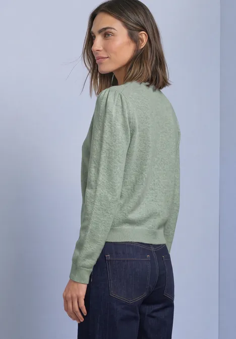 Langarm Cardigan mit Rundhals und Knöpfen eucalyptus green mel. Frau in grünem Pullover und blauen Jeans, seitlich stehend.