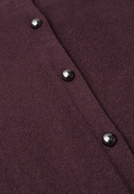 Nahaufnahme eines dunkelroten Strickstoffs mit drei schwarzen Knöpfen.