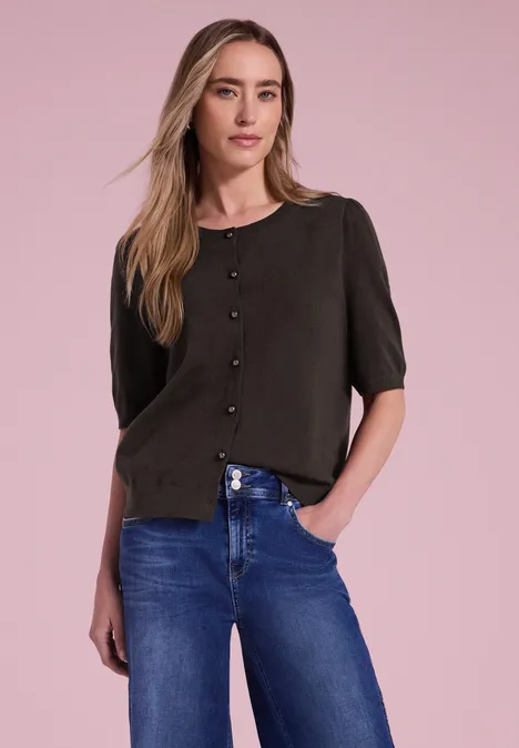 Kurzarm Cardigan mit Rundhals und Knöpfen black coffee Frau vor rosa Hintergrund in schwarzer Bluse mit Knöpfen und blauen Jeans