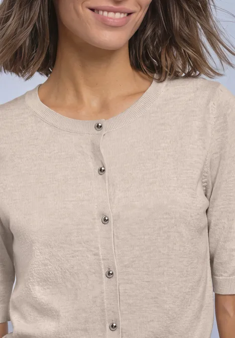 Beige Kurzarm-Strickjacke mit schwarzen Knöpfen.