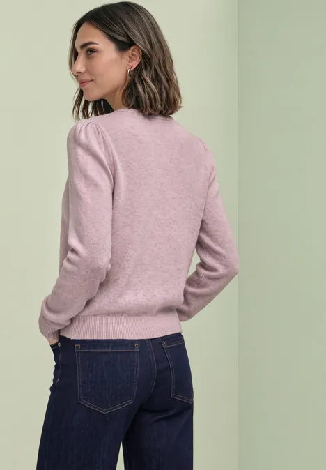 Langarm Cardigan mit Rundhals und Knöpfen quiet rose mel. Frau in rosa Pullover und dunkler Jeans, seitlich vom Rücken zu sehen, vor hellem Hintergrund.