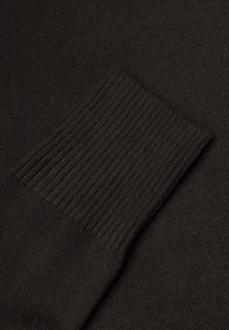 Nahaufnahme eines schwarzen Strickärmelbündchens.