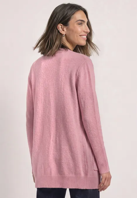 Frau trägt langen rosa Strickcardigan mit Taschen vor hellem Hintergrund.