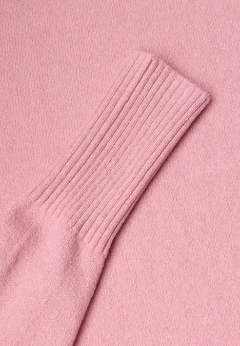 Nahaufnahme eines rosa Strickkleidungsstücks mit Rippbündchen.