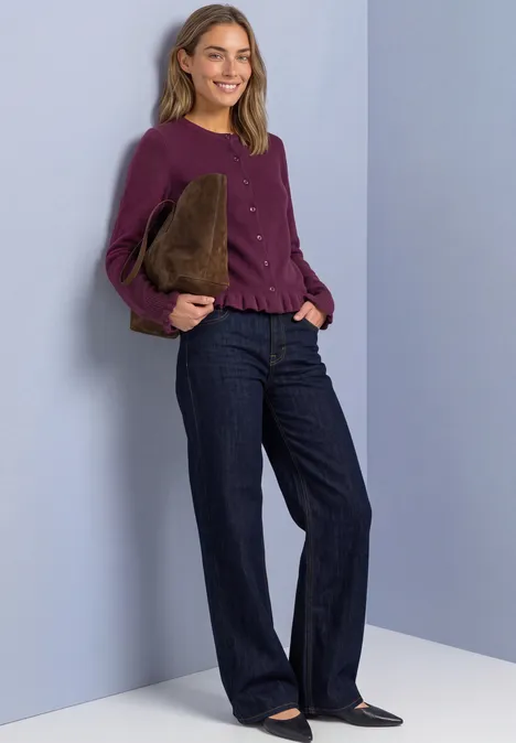 Cardigan mit Rundhals und Rüschendetails berry maroon Frau trägt purpurfarbenes Oberteil, weite Jeans und hält eine braune Plüschtasche vor lila Wand.
