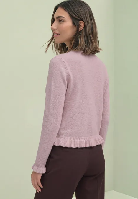 Cardigan mit Rundhals und Rüschendetails quiet rose mel. Eine Frau in rosa Strickpullover und dunkler Hose, im Profil vor hellem Hintergrund.