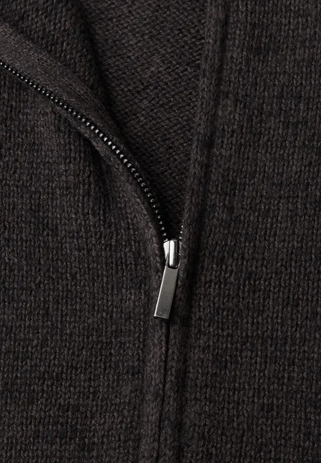 Vest met afhangende schouders, coltrui en ritssluiting black coffee mel. Nahaufnahme eines dunkelbraunen Strickstoffs mit sichtbarem Reißverschluss