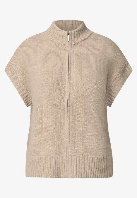 Beige gebreide cape met rits, opstaande kraag en korte mouwen.