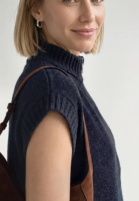 Vest met afhangende schouders, coltrui en ritssluiting indigo night mel. Frau im dunkelblauen ärmellosen Rollkragenpullover mit brauner Tasche.