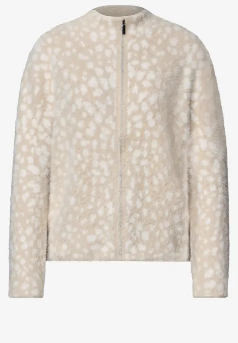 Beige Teddy-Jacke mit Reißverschluss und dezenten weißen Tupfen, langärmlig.