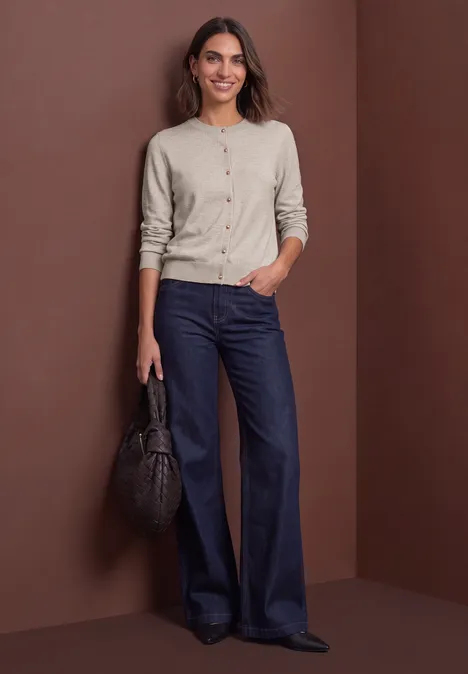 Cardigan mit Rundhals und Knopfleiste clay sand mel. Frau trägt beigefarbenen Cardigan und weite dunkelblaue Jeans, sie hält eine schwarze Handtasche.